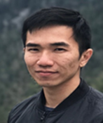 Portrait of Lee Zen Wea in dark jacket outdoors with blurred greenery in the background.